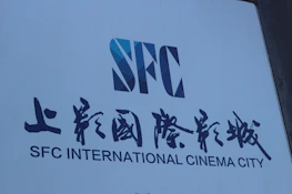 Close-up of the golden CISF Films logo illuminated against a sleek black background.