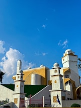 Bright, warm yellow gradient mosque building exterior during daylight.