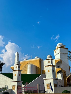 Bright, warm yellow gradient mosque building exterior during daylight.