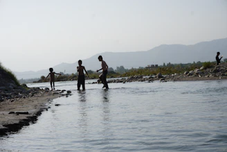 Wide shot of a clean river with team members conducting water quality tests.