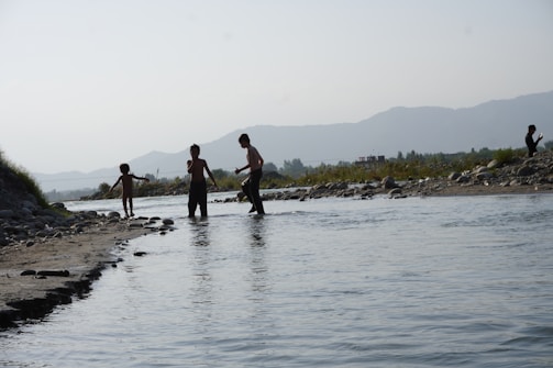 Fieldwork team conducting wildlife habitat assessment near a river.