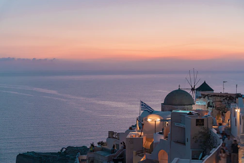 A warm sunset over a peaceful Greek island coastline, symbolizing hope and care for the environment.
