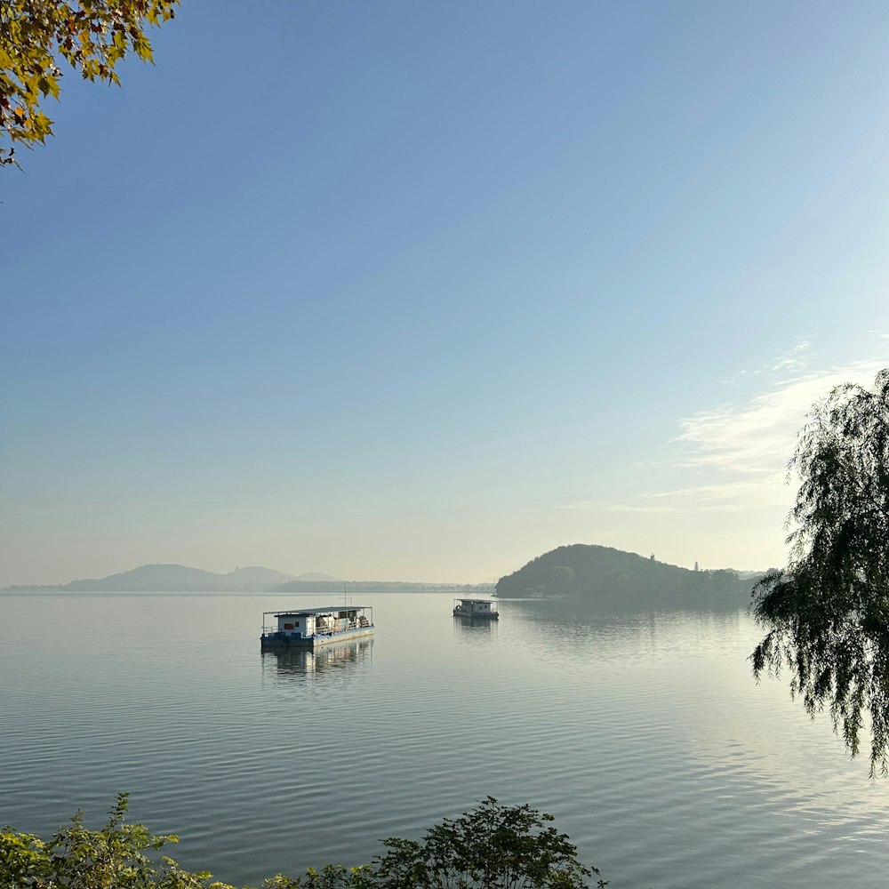 a couple of boats floating on top of a lake