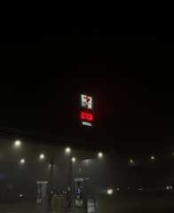 A dimly lit gas station at night with a visible 7-Eleven logo and a price display for diesel reading 279.9. The surroundings are dark, with only a few streetlights illuminating the scene.