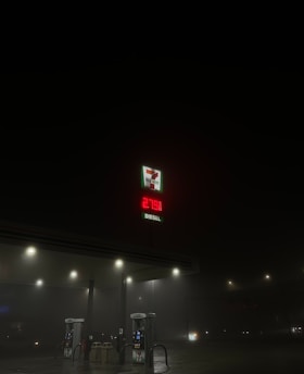 A dimly lit gas station at night with a visible 7-Eleven logo and a price display for diesel reading 279.9. The surroundings are dark, with only a few streetlights illuminating the scene.