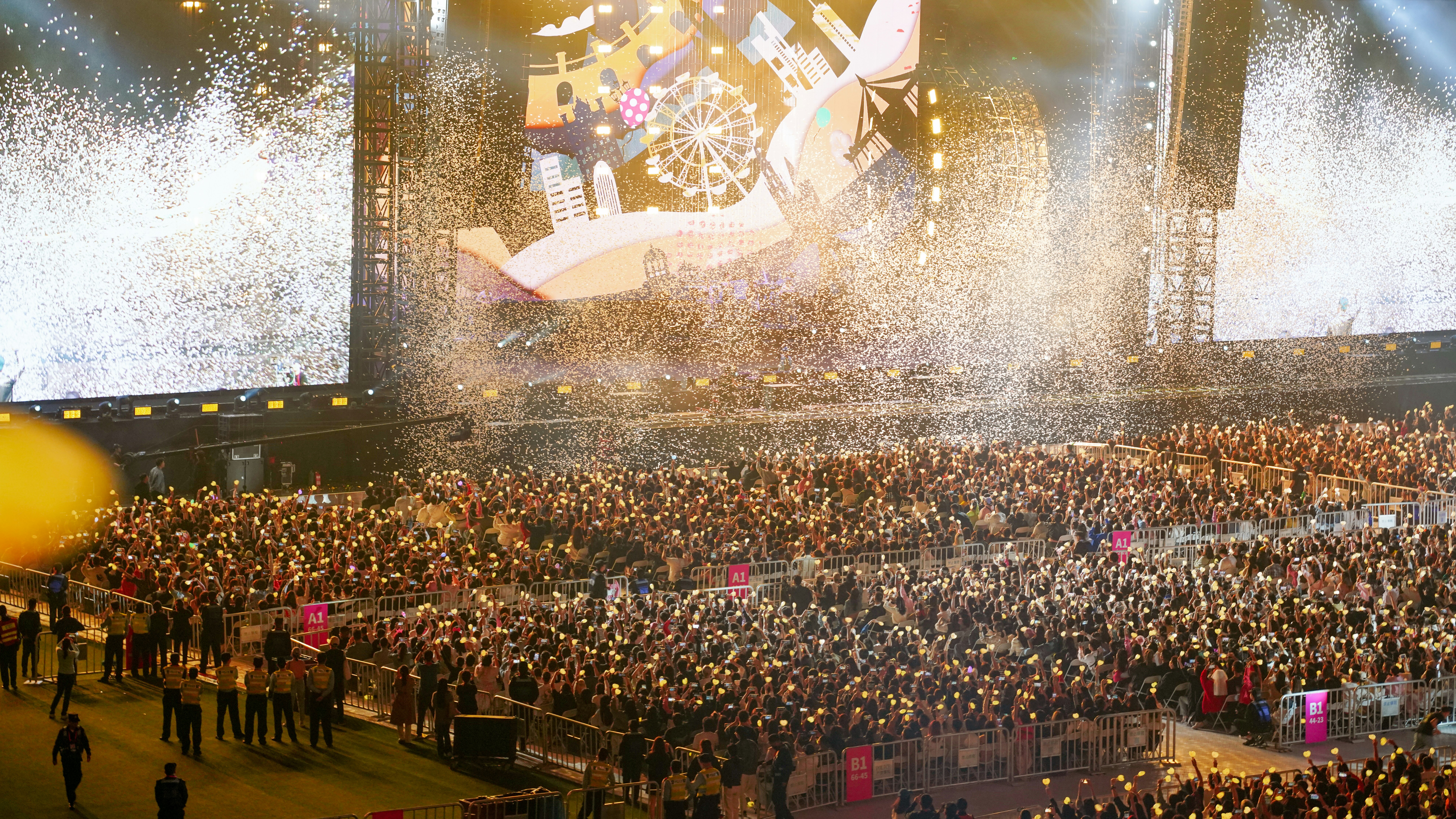 a large crowd of people standing around a stage