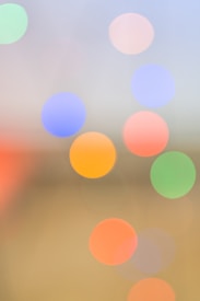 A blurred background with several out-of-focus, colorful circles resembling bokeh lights. The circles vary in colors, including blue, orange, pink, green, and red, creating an abstract and dreamy effect.