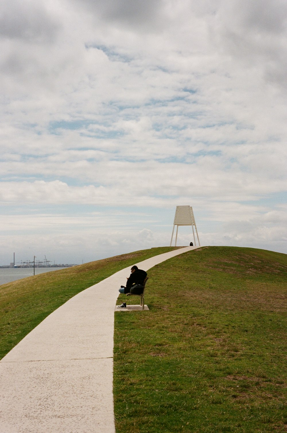 a bench sitting on top of a grass covered hill