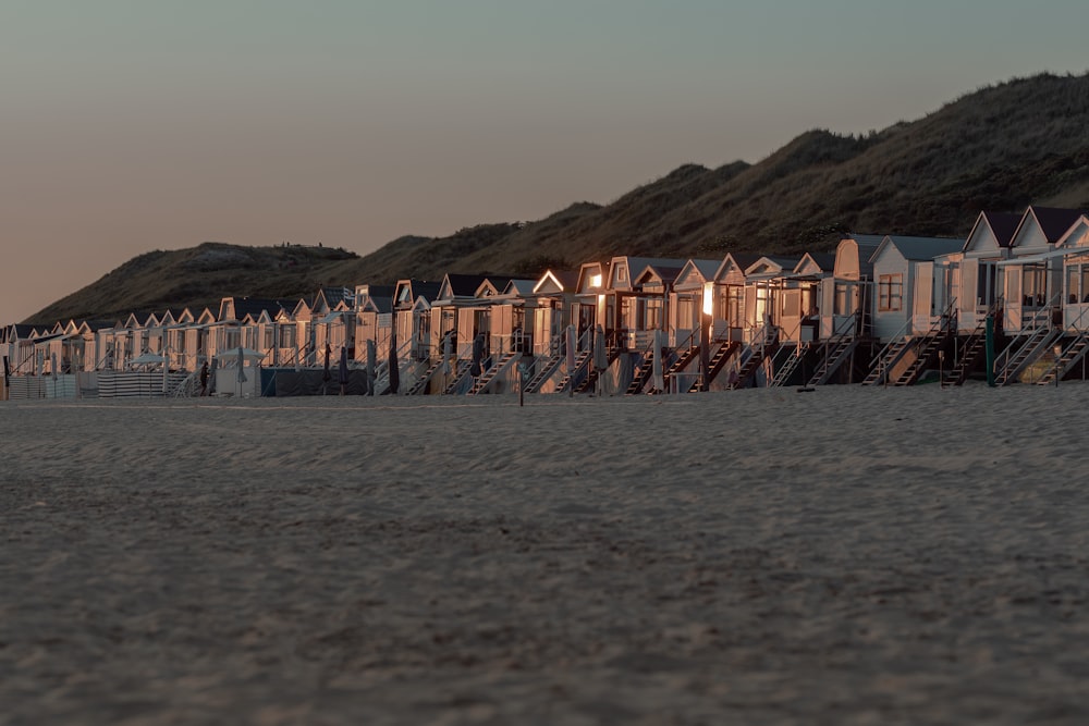 a row of beach huts sitting on top of a sandy beach