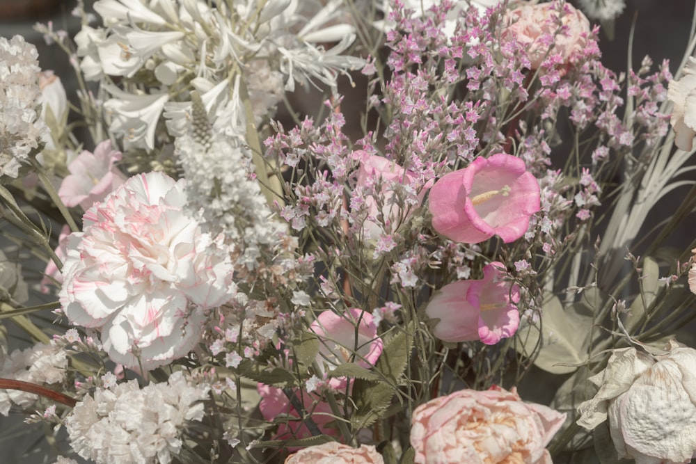 a vase filled with lots of pink and white flowers