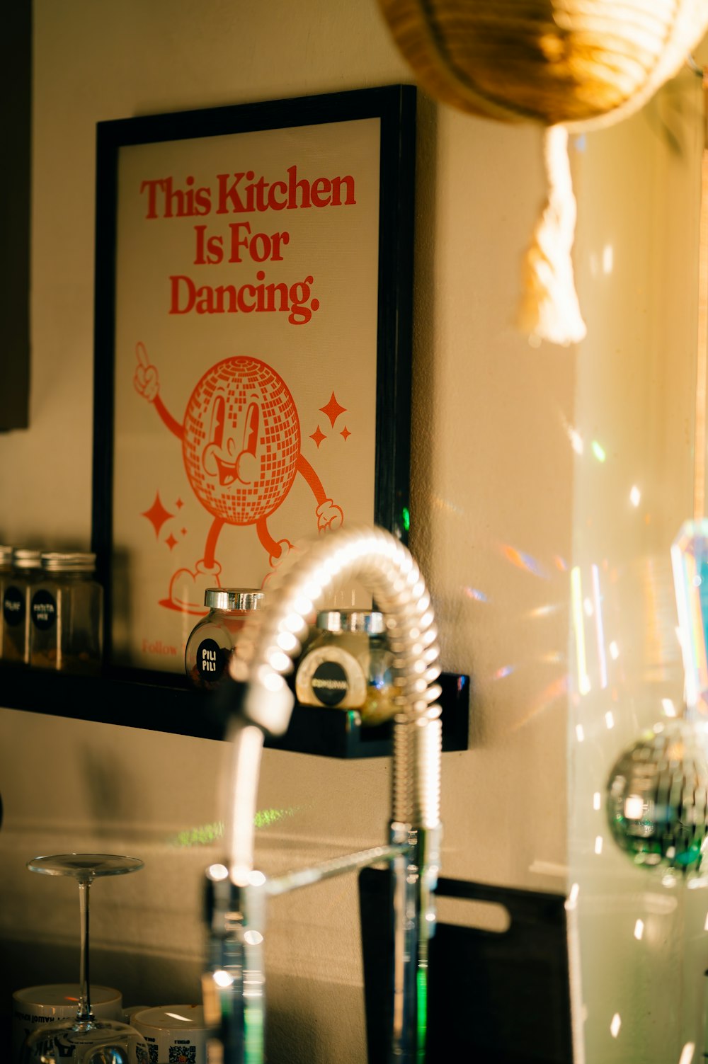 a kitchen sink with a faucet and a poster above it