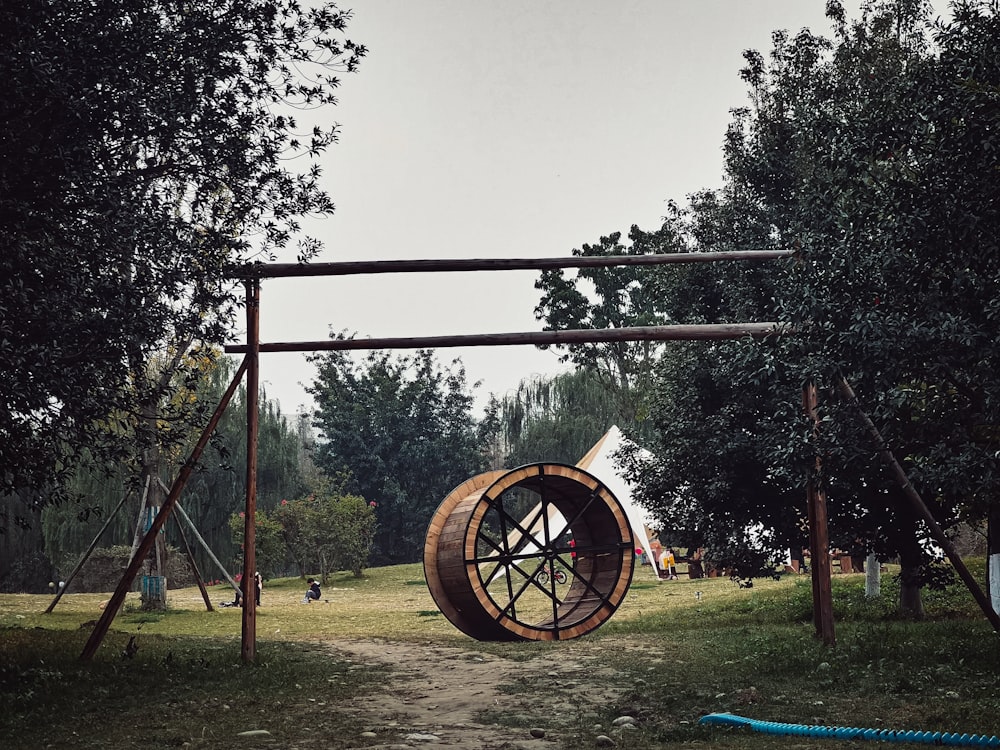 a wooden swing set with a wheel on top of it