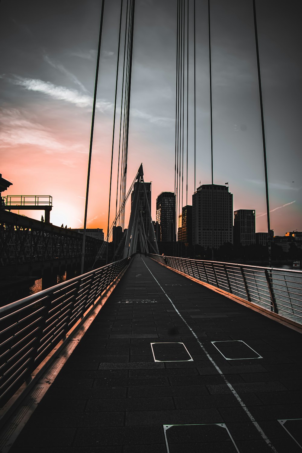 a bridge with a view of a city at sunset