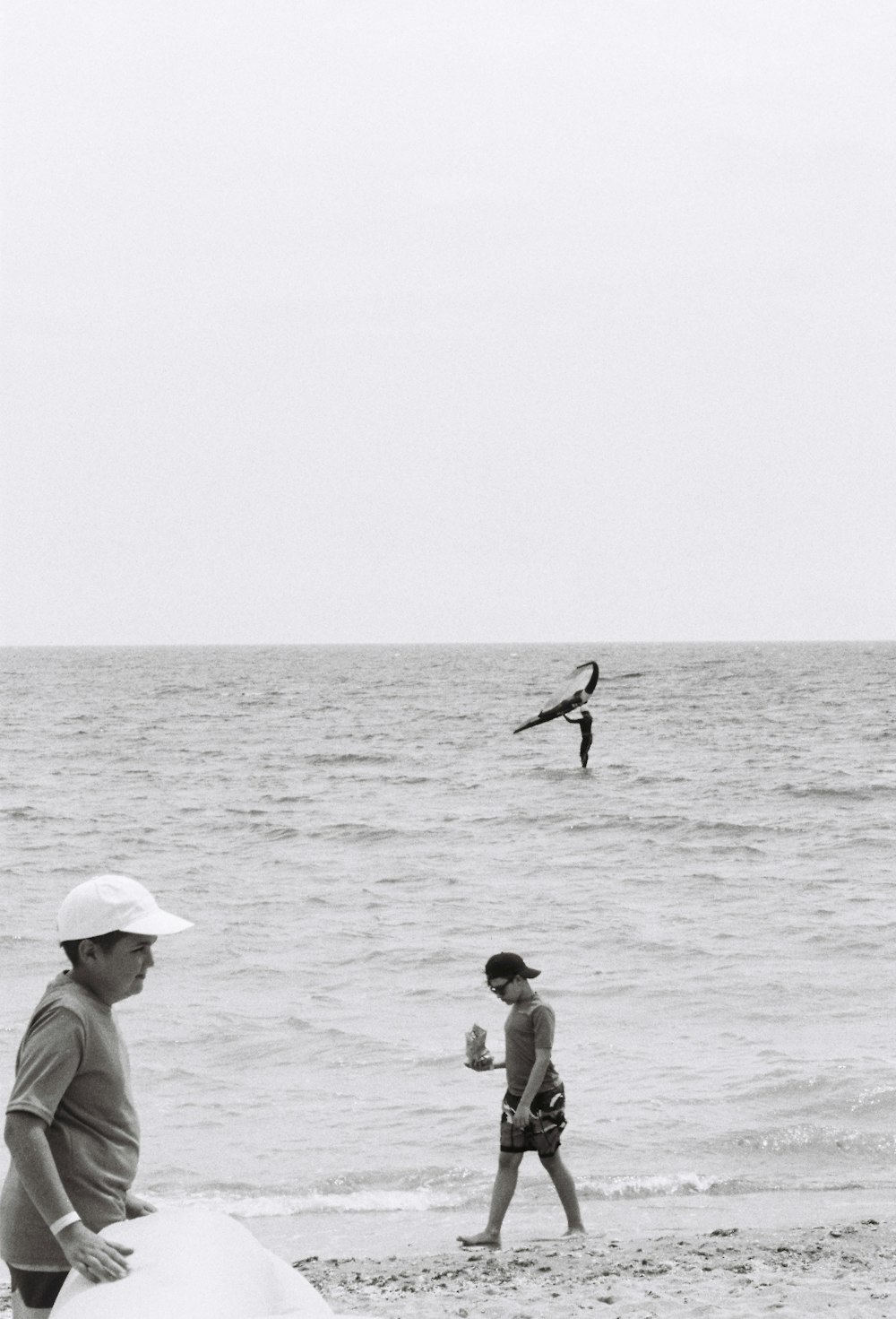 una foto in bianco e nero di persone sulla spiaggia