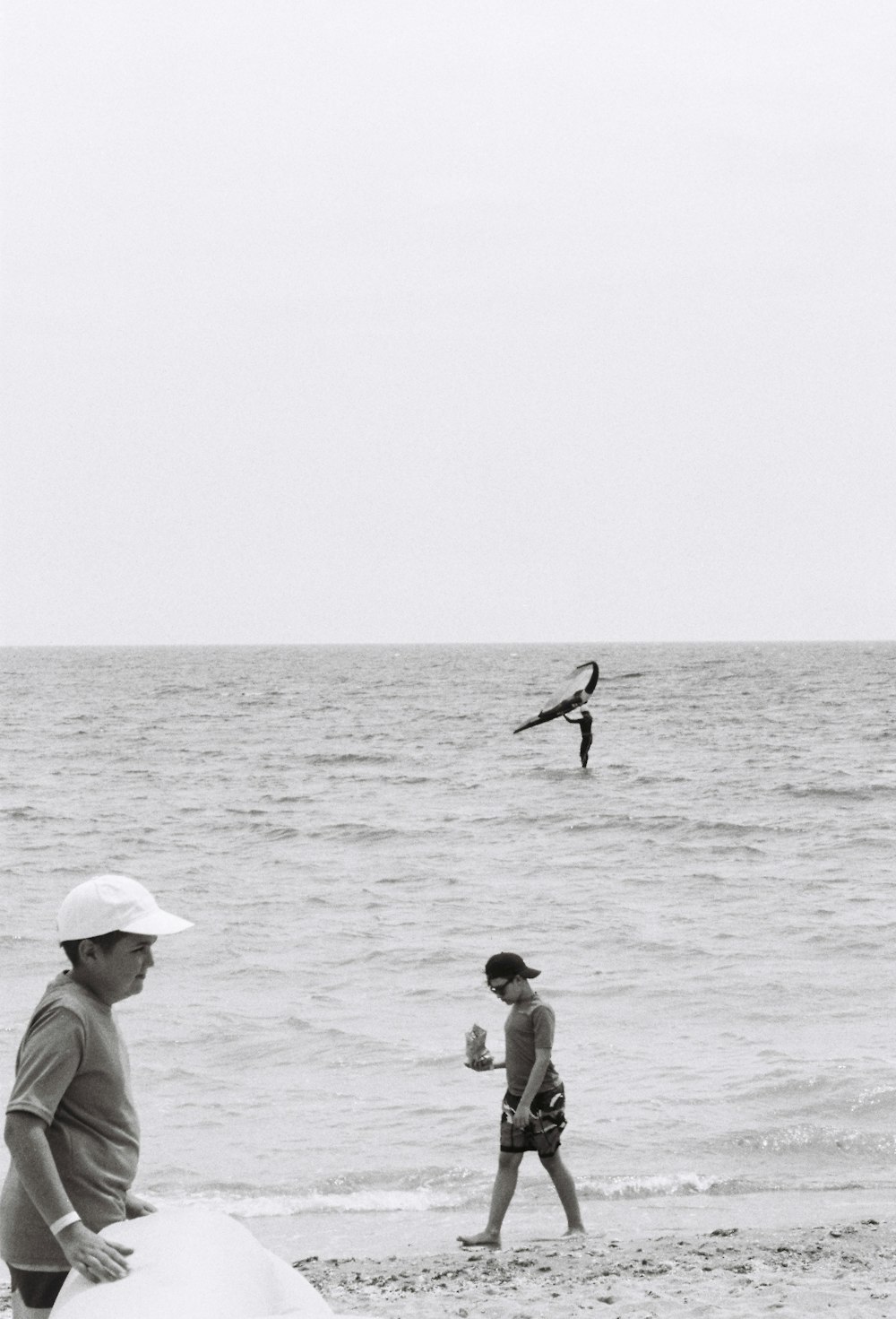 a black and white photo of people on the beach