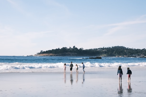 Guests enjoying a morning walk along the sandy beach near the hotel.