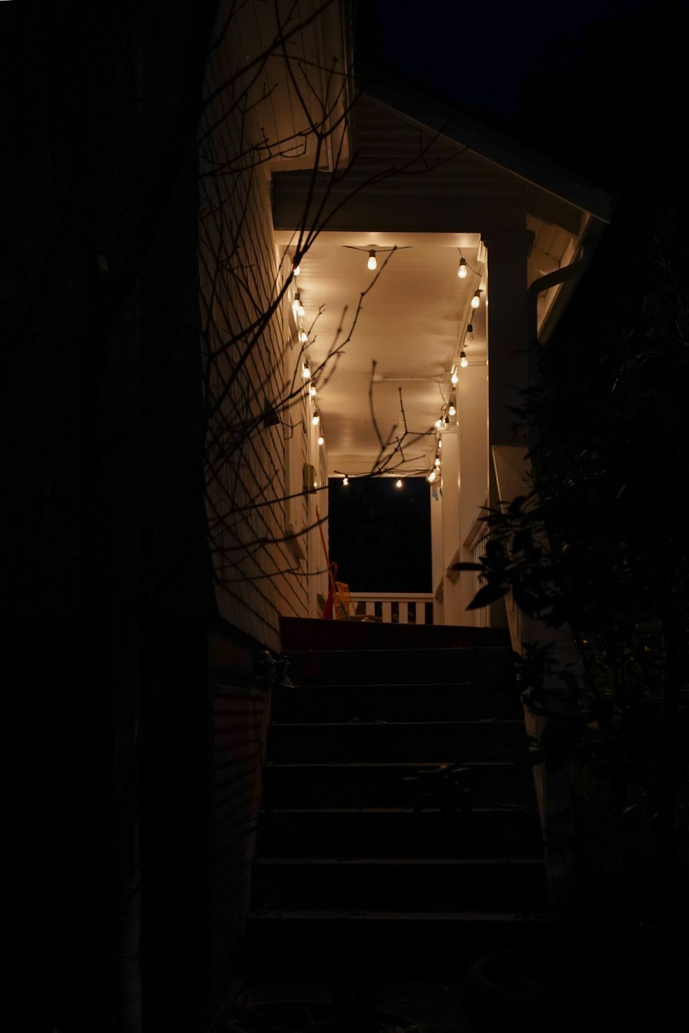 a set of stairs leading up to a house covered in christmas lights