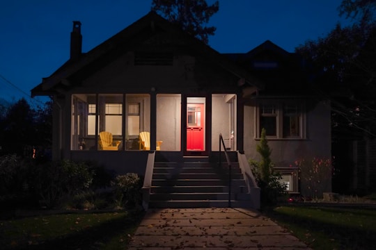 A welcoming front porch of a cozy community residence with warm lighting at dusk.
