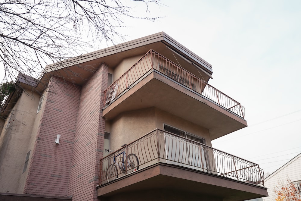 a tall building with a balcony and a bike on the balcony