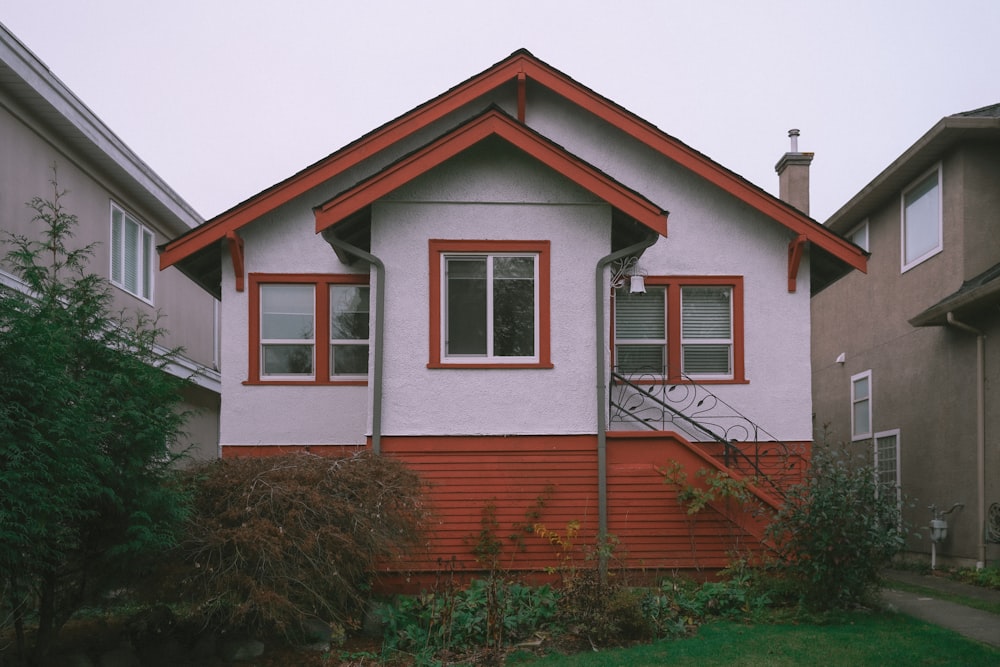 a red and white house with a red window