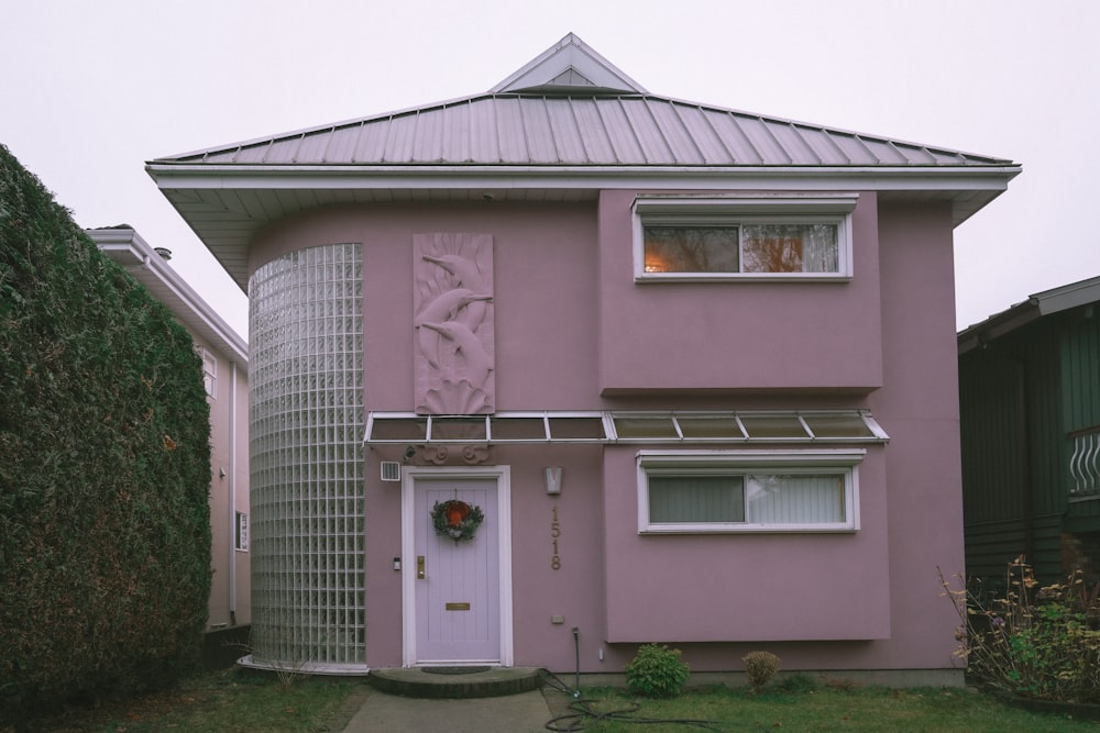 a pink house with a white door and window