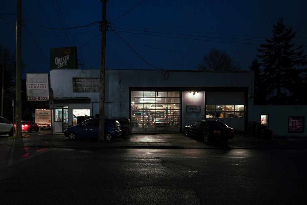 a car is parked in front of a store at night