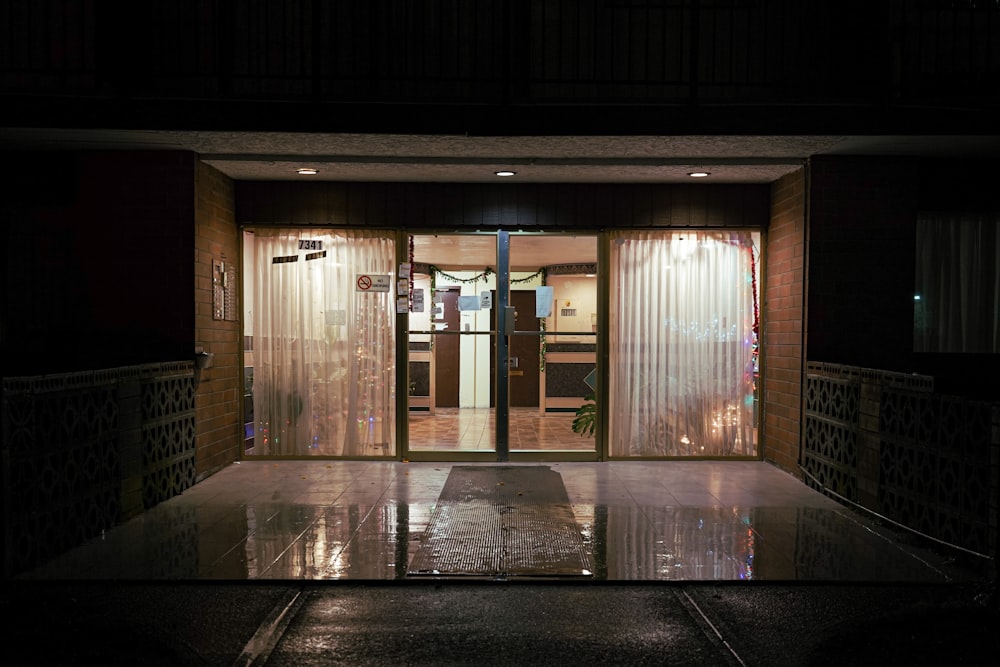 the entrance to a building at night with lights on