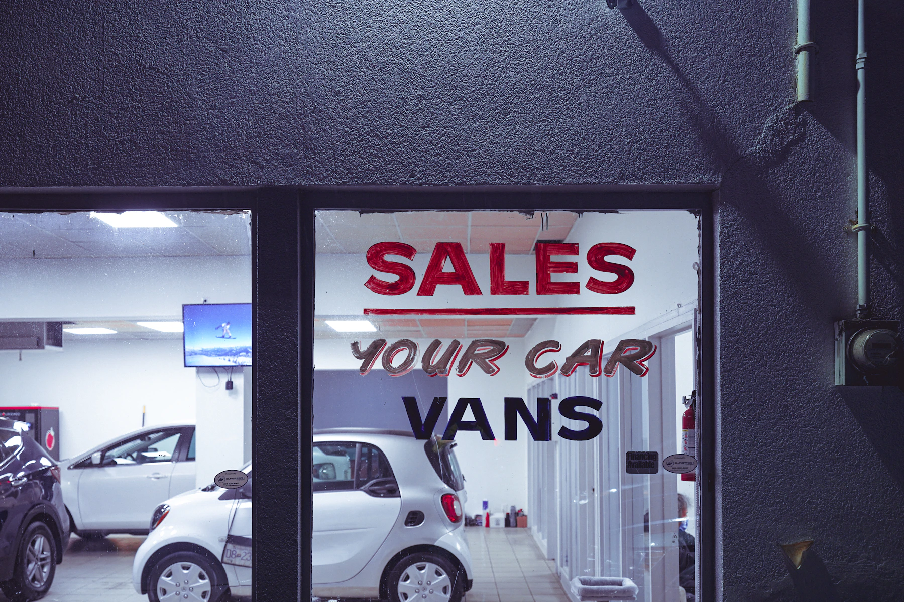 Car dealership showroom with a sales sign in the window