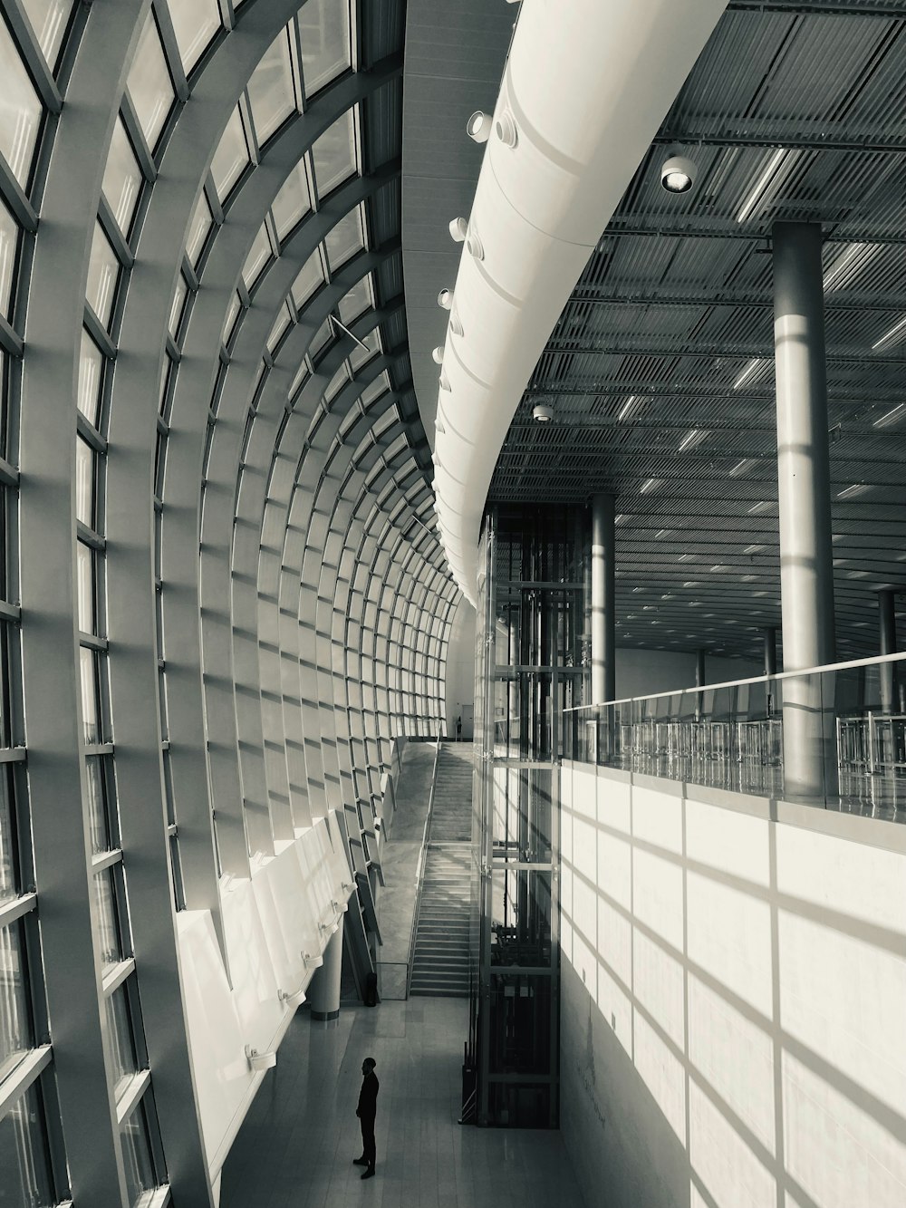 a black and white photo of a person in a large building