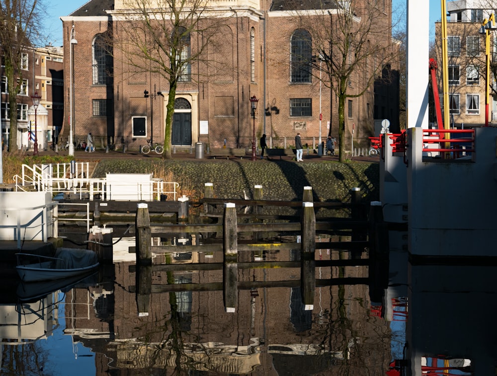 a building with a clock tower reflected in a body of water