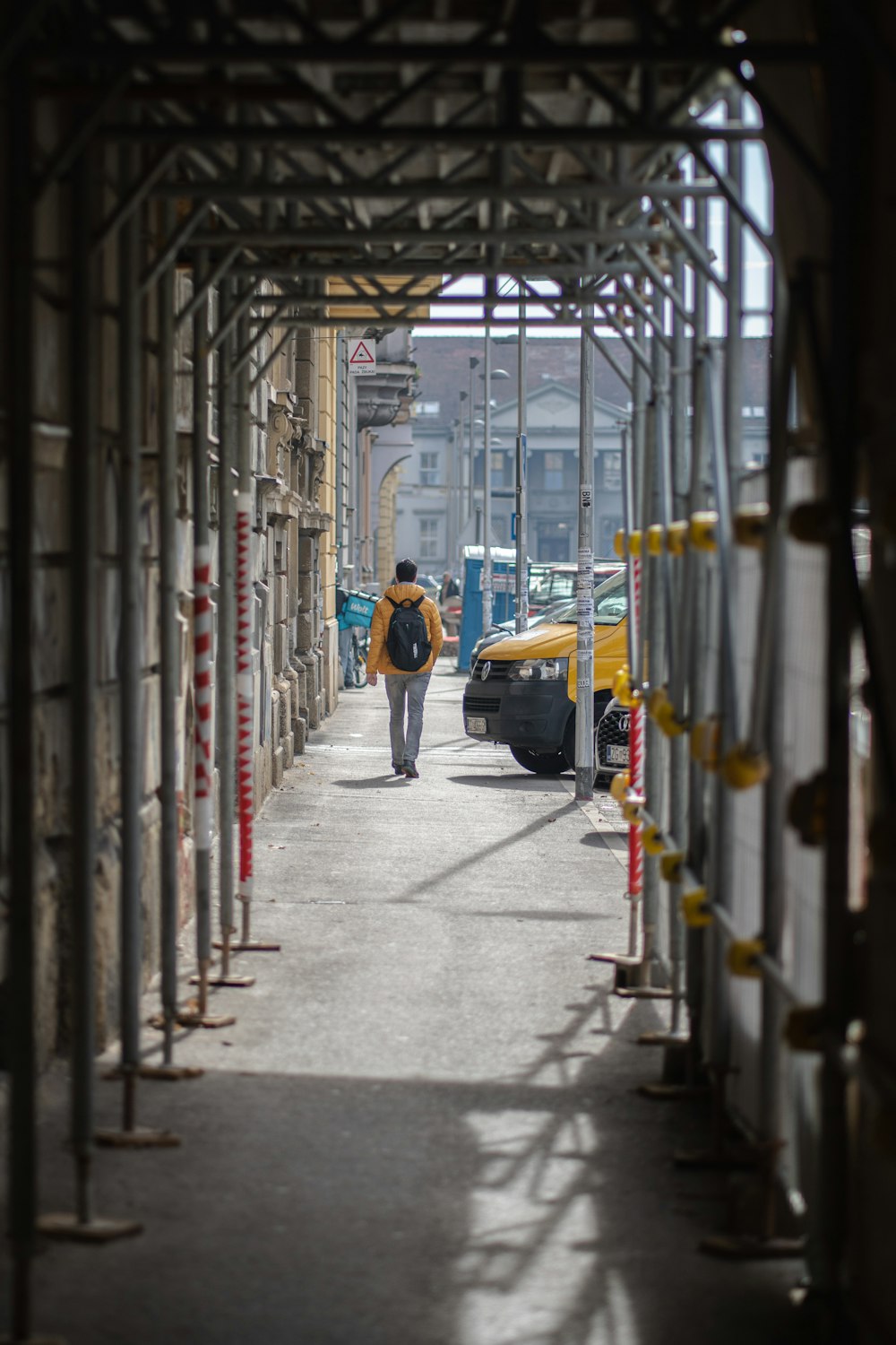 a person walking down a street next to a yellow bus