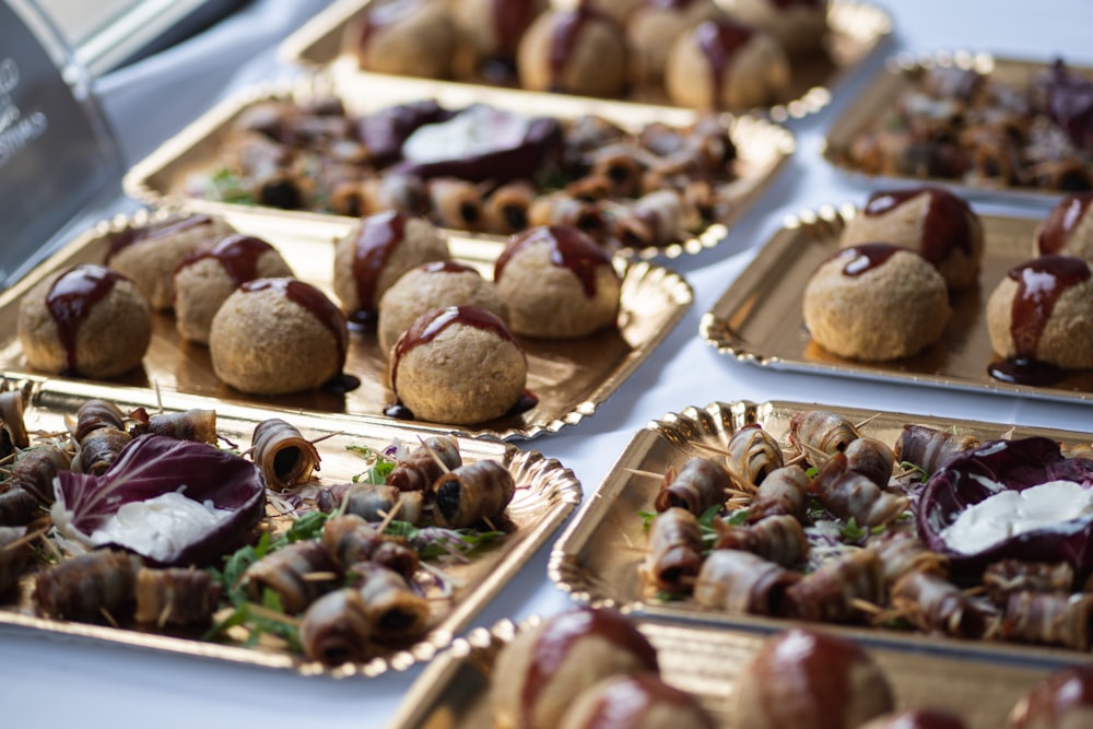 a table topped with trays of food covered in toppings