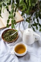 a cup of tea next to a bowl of tea and a book
