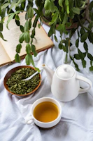 a cup of tea next to a bowl of tea and a book