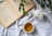 An open book and a steaming cup of tea on a vibrant table setting.