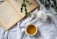 An open book and a steaming cup of tea on a vibrant table setting.