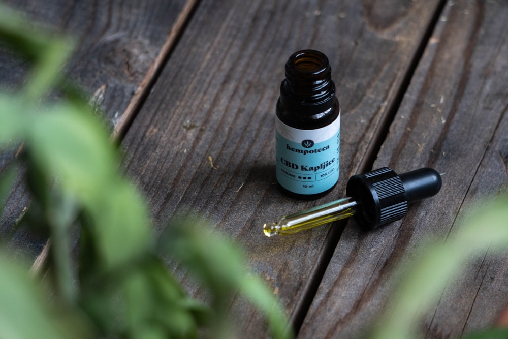 a bottle of essential oils sitting on a wooden table