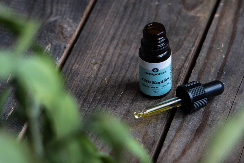 a bottle of essential oils sitting on a wooden table