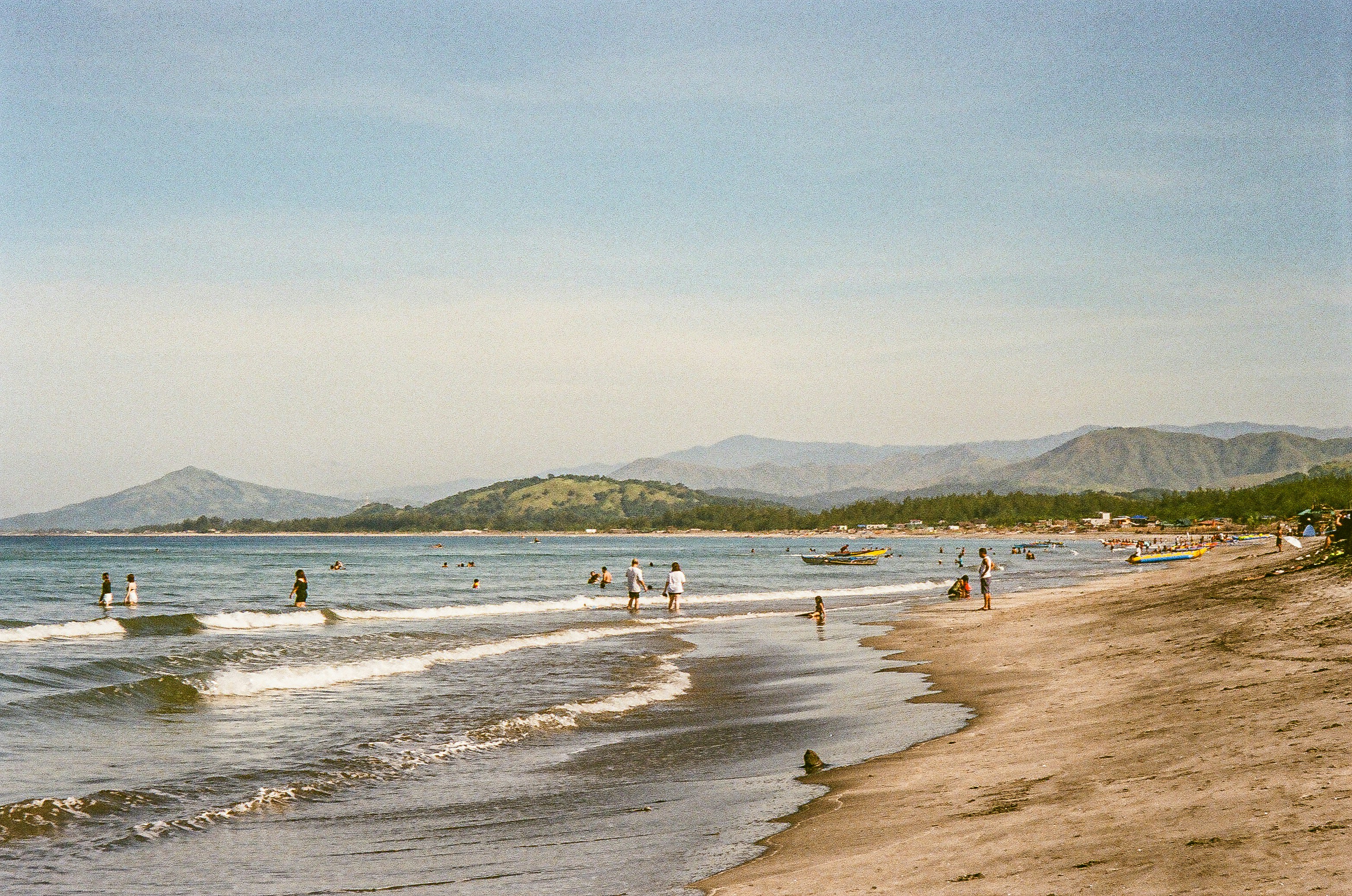 a group of people standing on top of a sandy beach