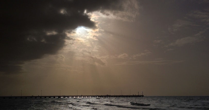 Golden sun rays filtering through clouds above Santa Barbara’s iconic pier.