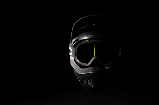 Close-up of a matte black full-face helmet with bright orange accents on a dark background.