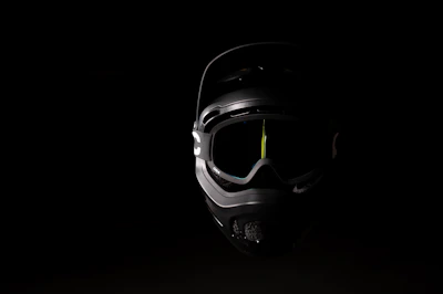 Close-up of a matte black full-face helmet with bright orange accents on a dark background.