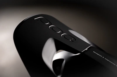 Close-up of a sleek black and gray POC radio device on a desk.