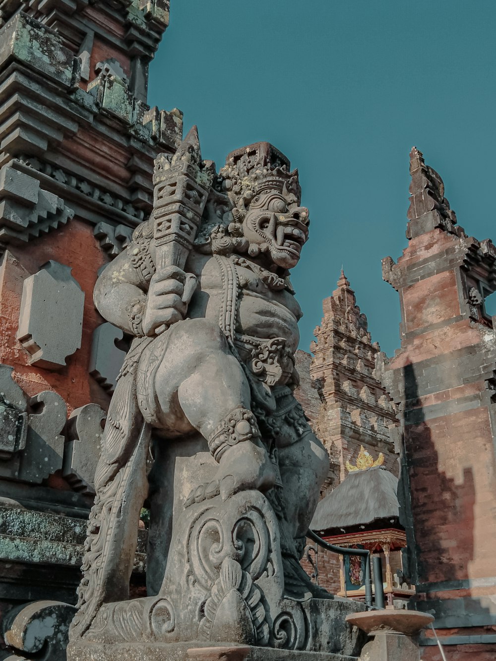 a statue of a man holding a sword in front of a building