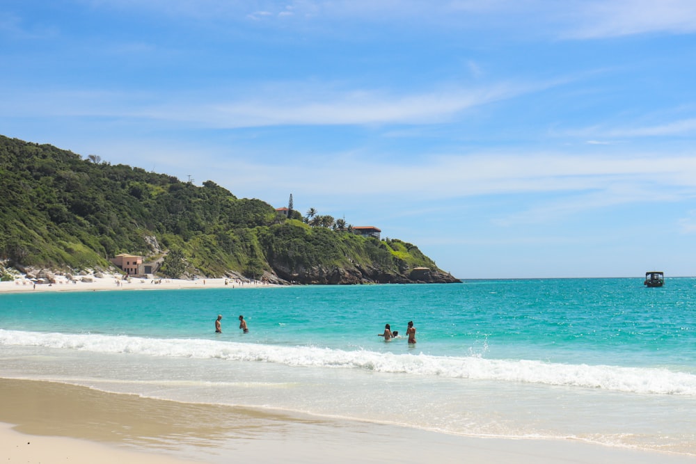 a group of people standing on top of a sandy beach