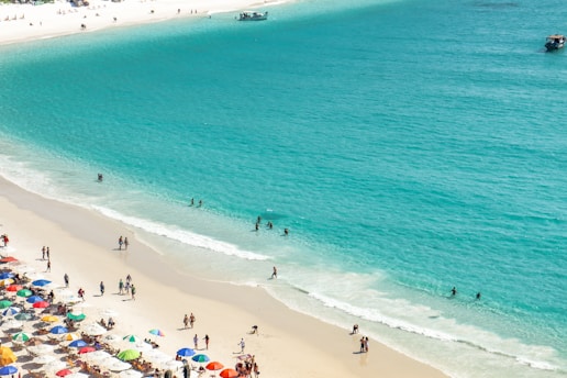 a group of people standing on top of a sandy beach