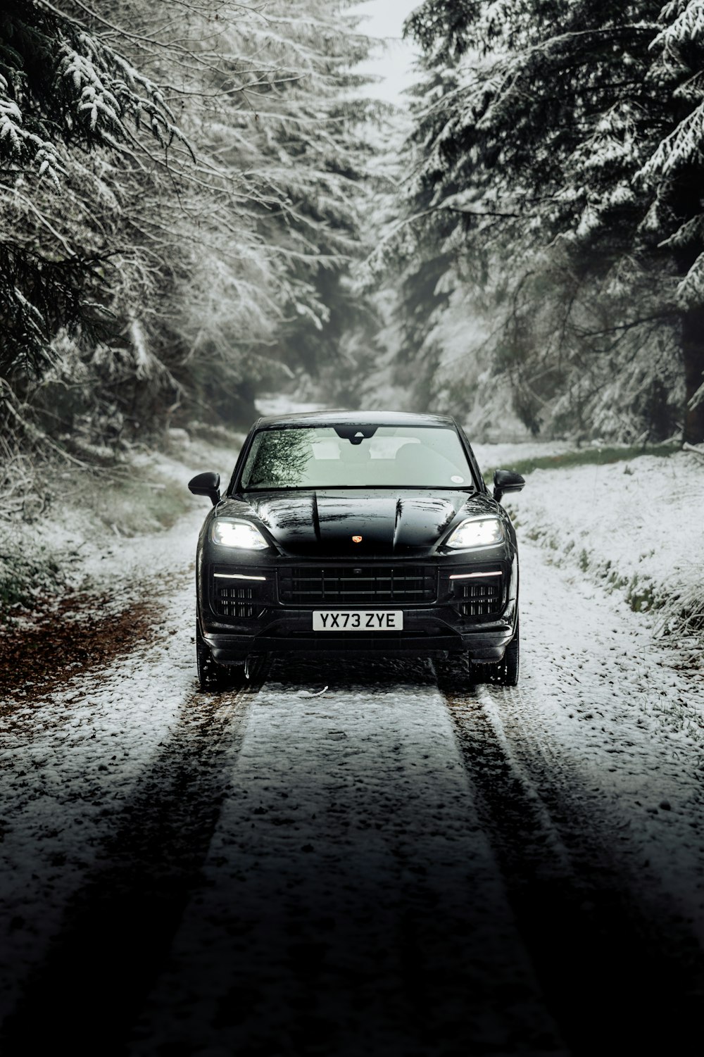 a car driving down a snow covered road