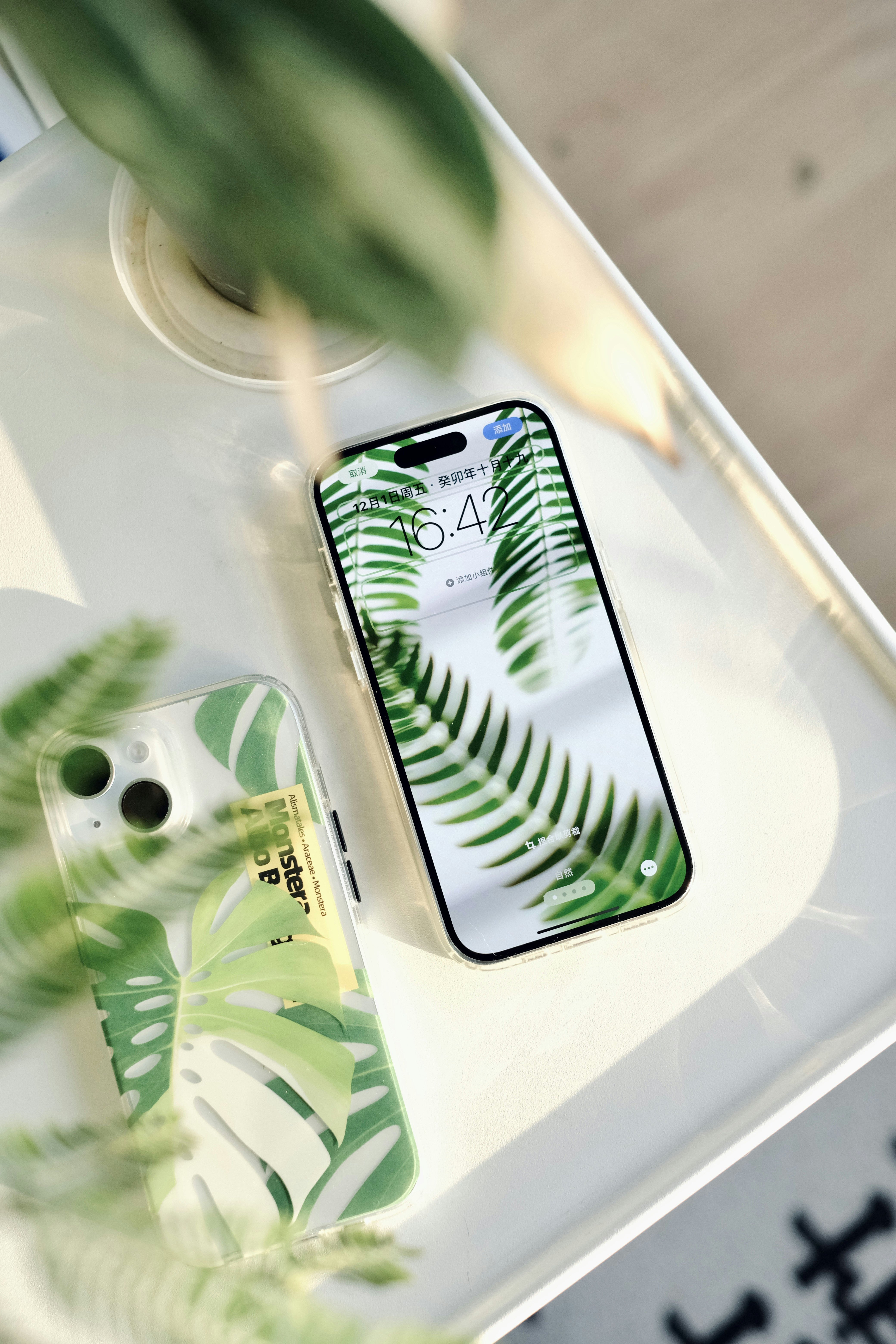 a cell phone sitting on top of a table next to a plant