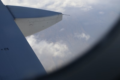 A close-up of airplane windows with clouds visible outside during flight.