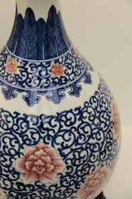 Close-up of a hand-painted ceramic vase with intricate floral designs.